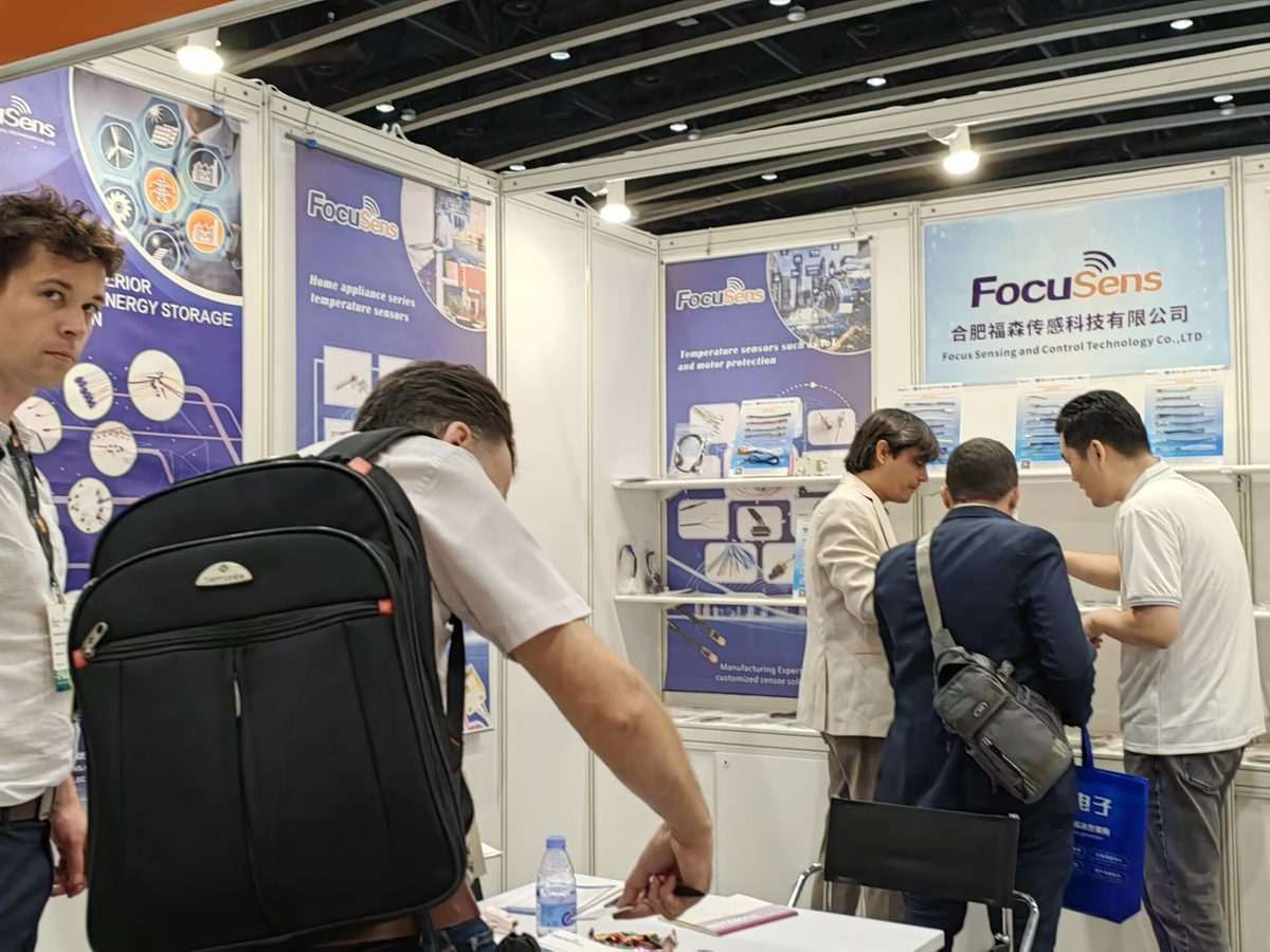 Focusens staff talking with buyers in front of home appliance and motor protection temperature sensor displays